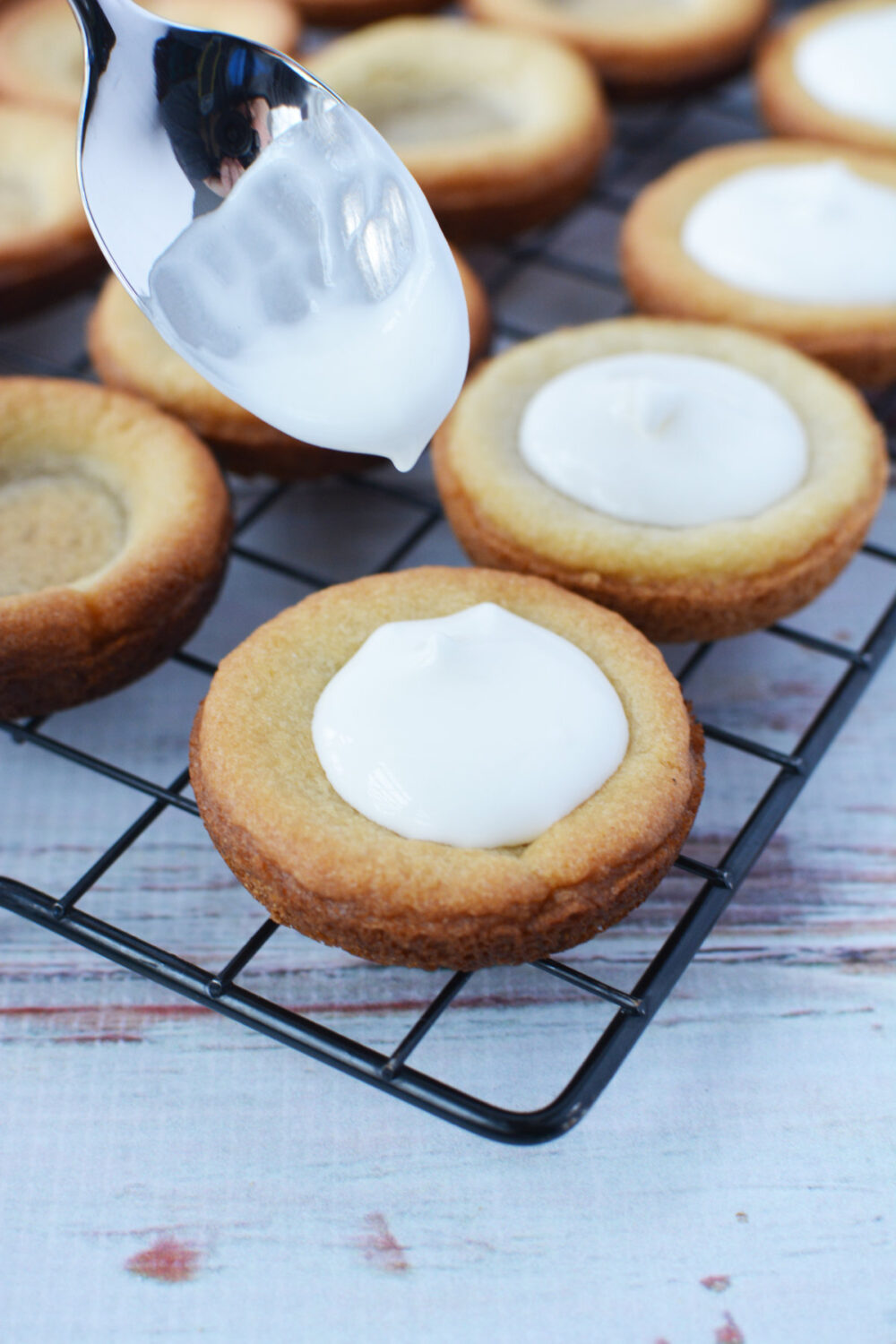 Filling cookie crusts with lemonade pie filling. 