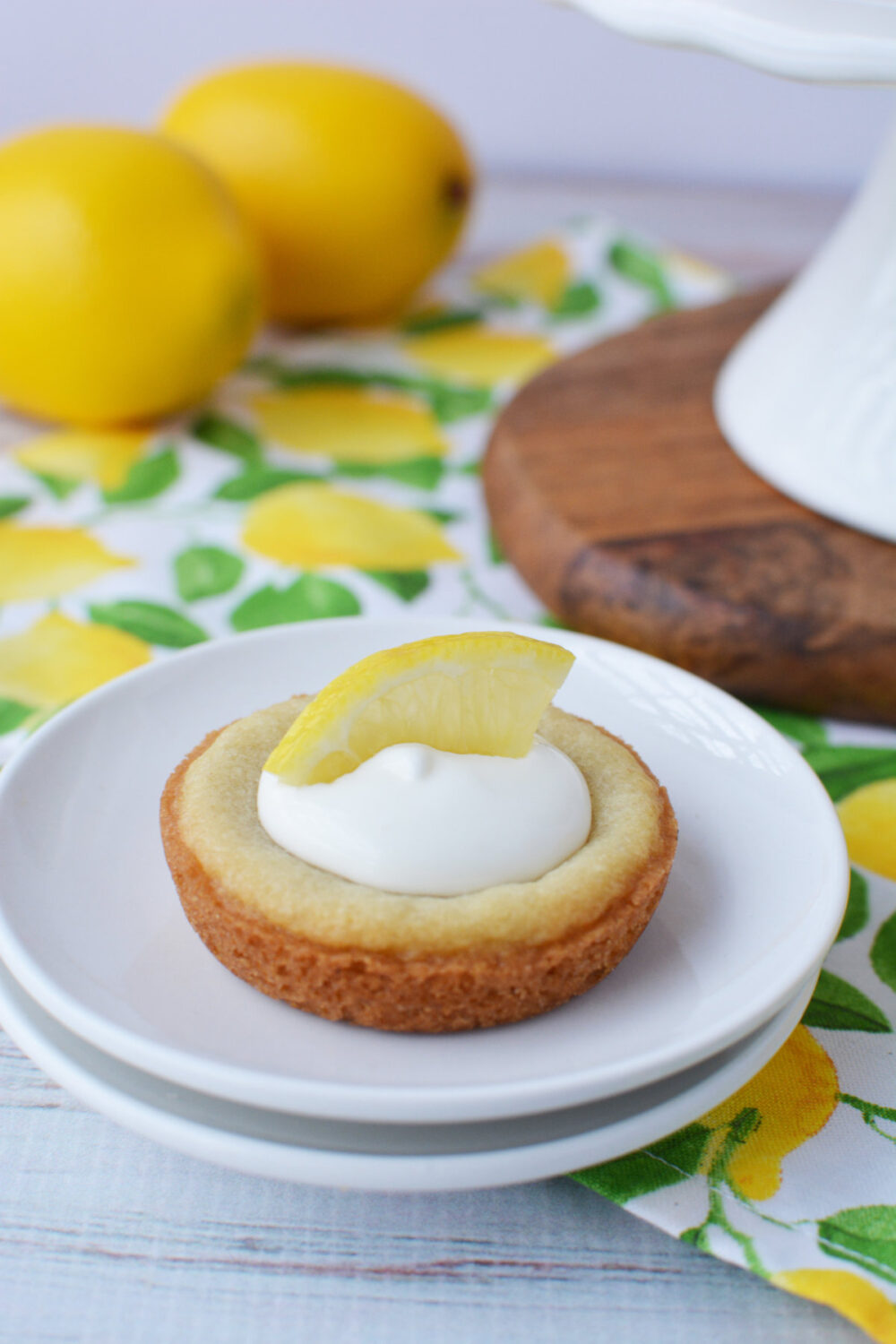 Lemonade sugar cookie mini pie on a plate with lemons on the table.