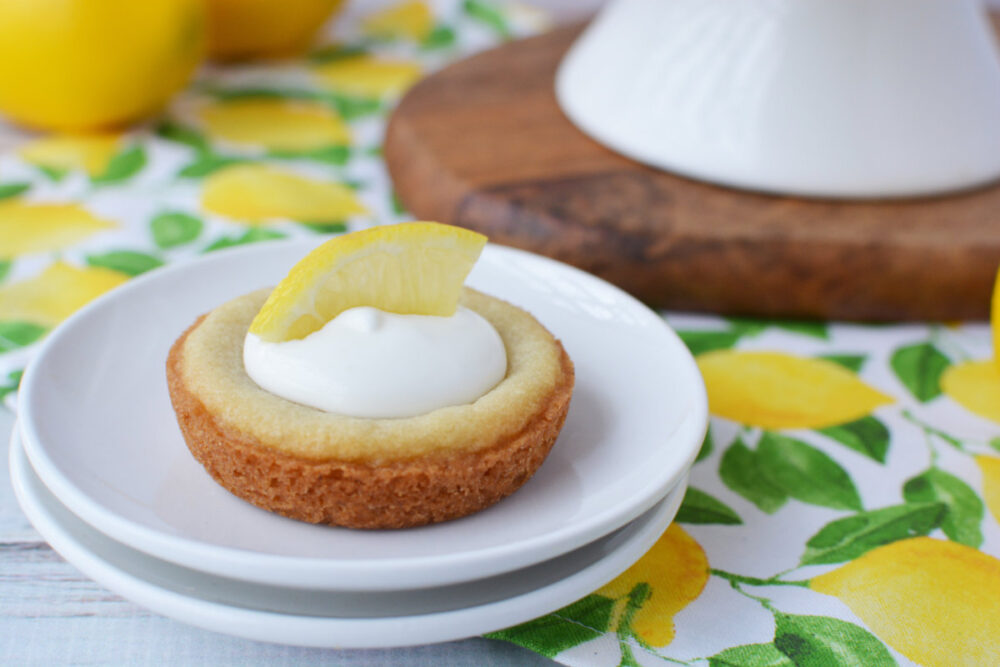 Lemonade pie cookie topped with whipped cream and lemon on a plate. 