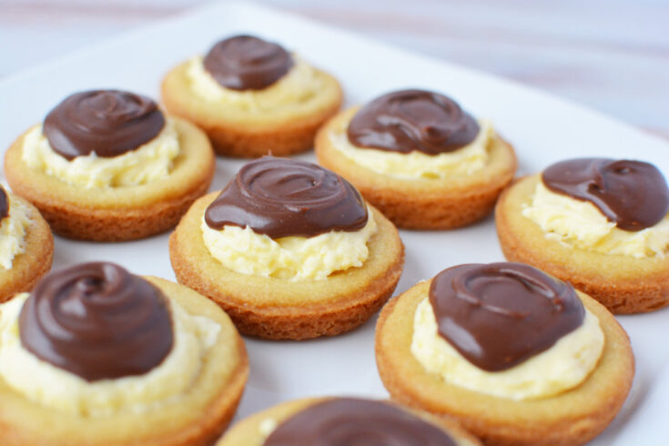 Plate of cream-filled cookies topped with chocolate.