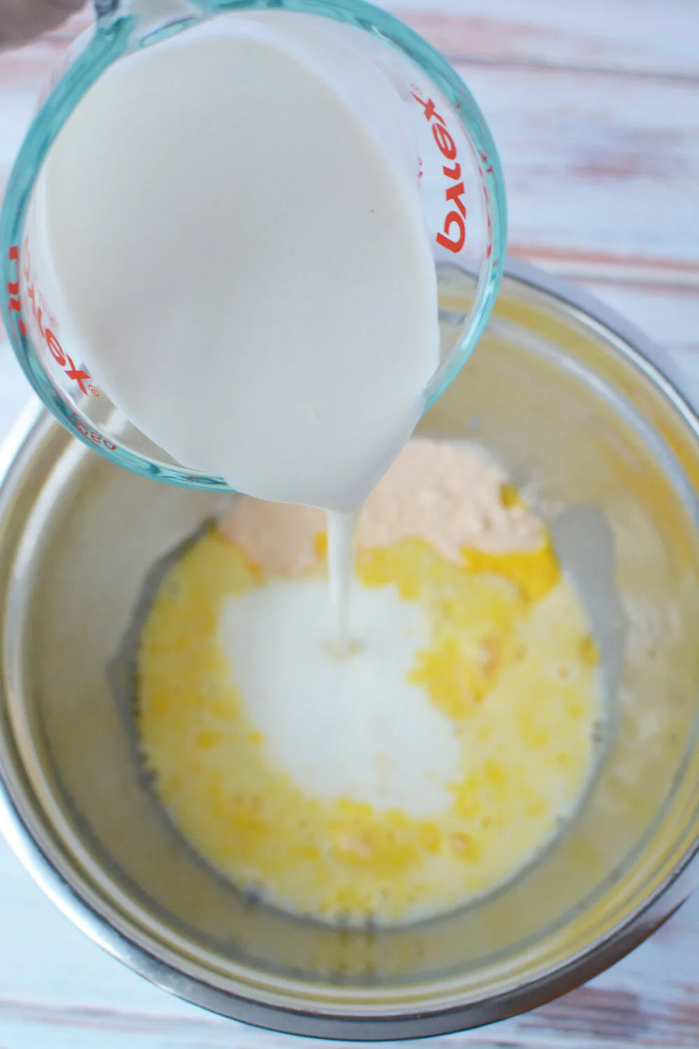 Adding heavy cream into mixing bowl with pudding mix.
