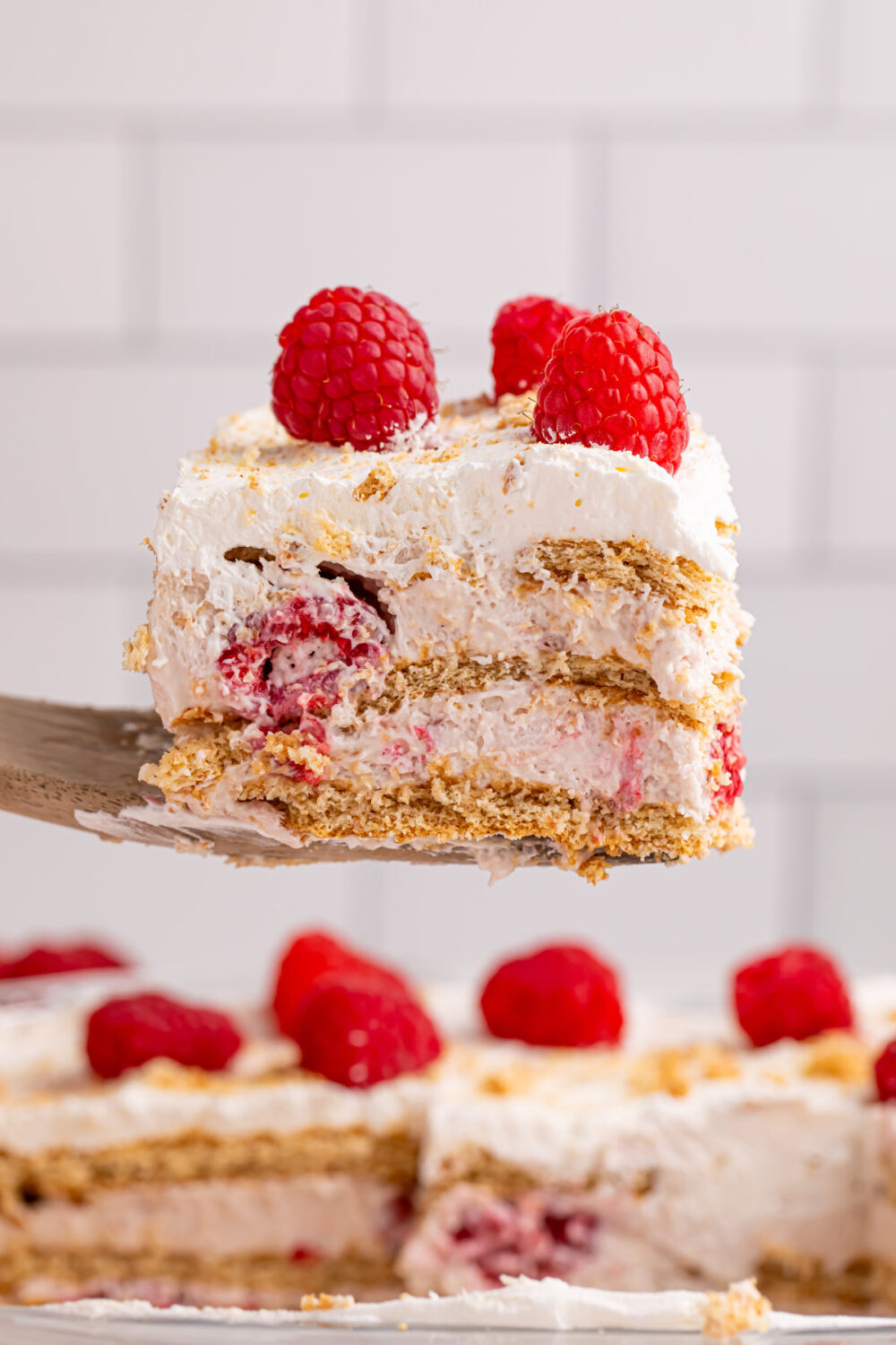 Raising a slice of raspberry icebox cake out of the pan. 