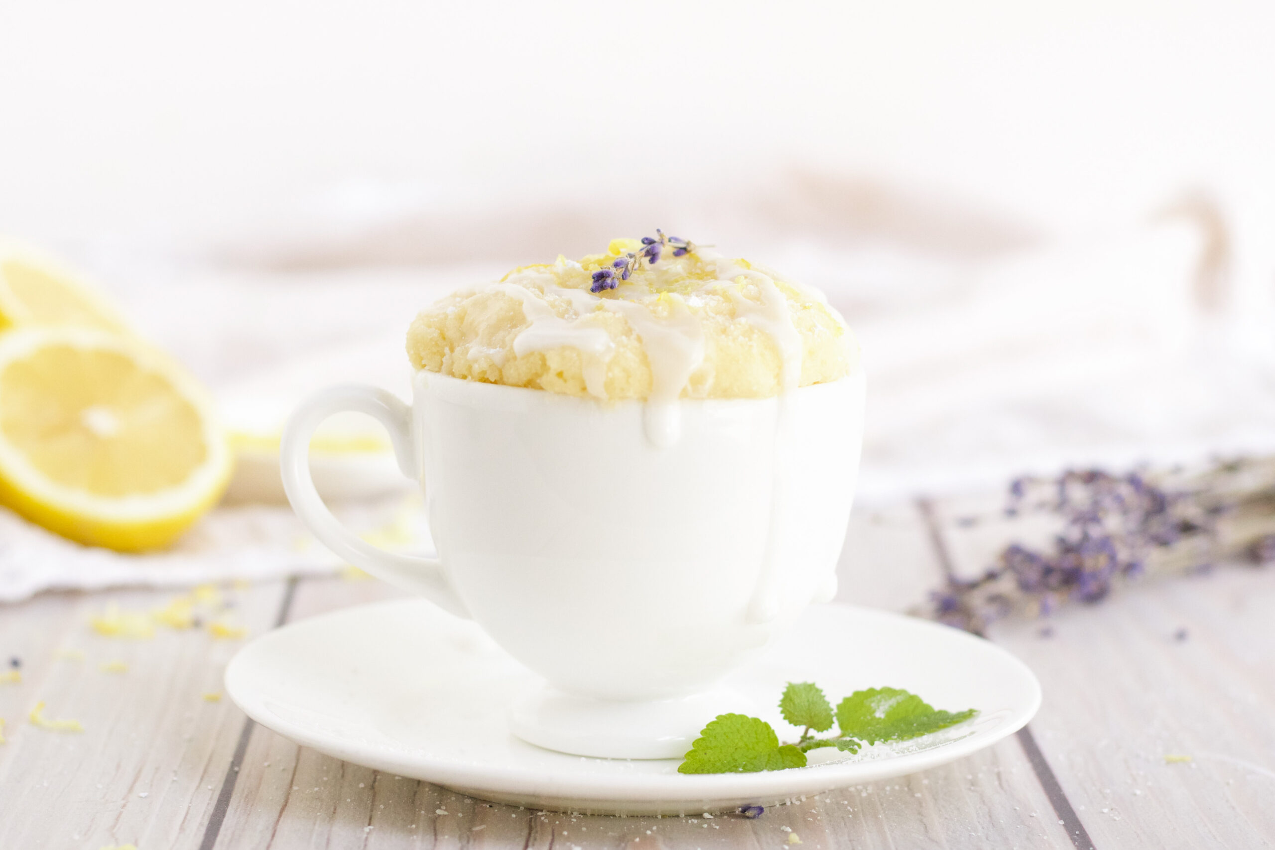 Lemon cake in a mug topped with lavender. 