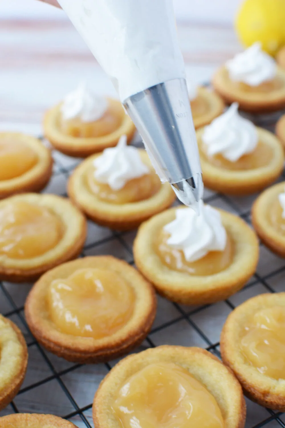 Piping meringue onto lemon cookies. 