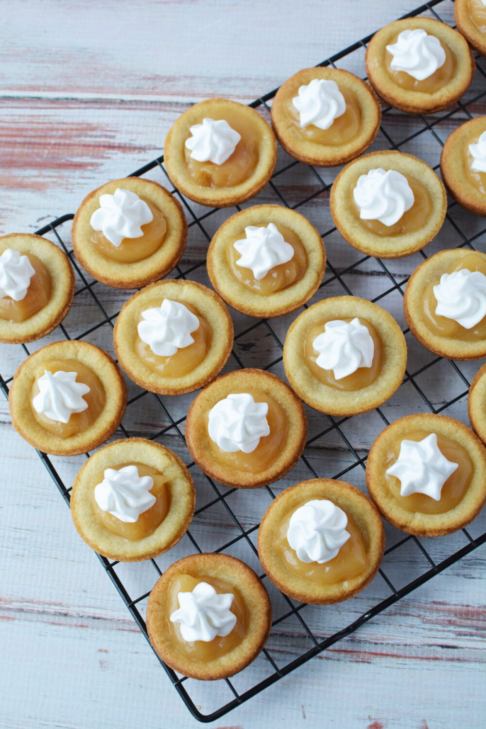 Lemon cookies topped with meringue on a wire rack. 
