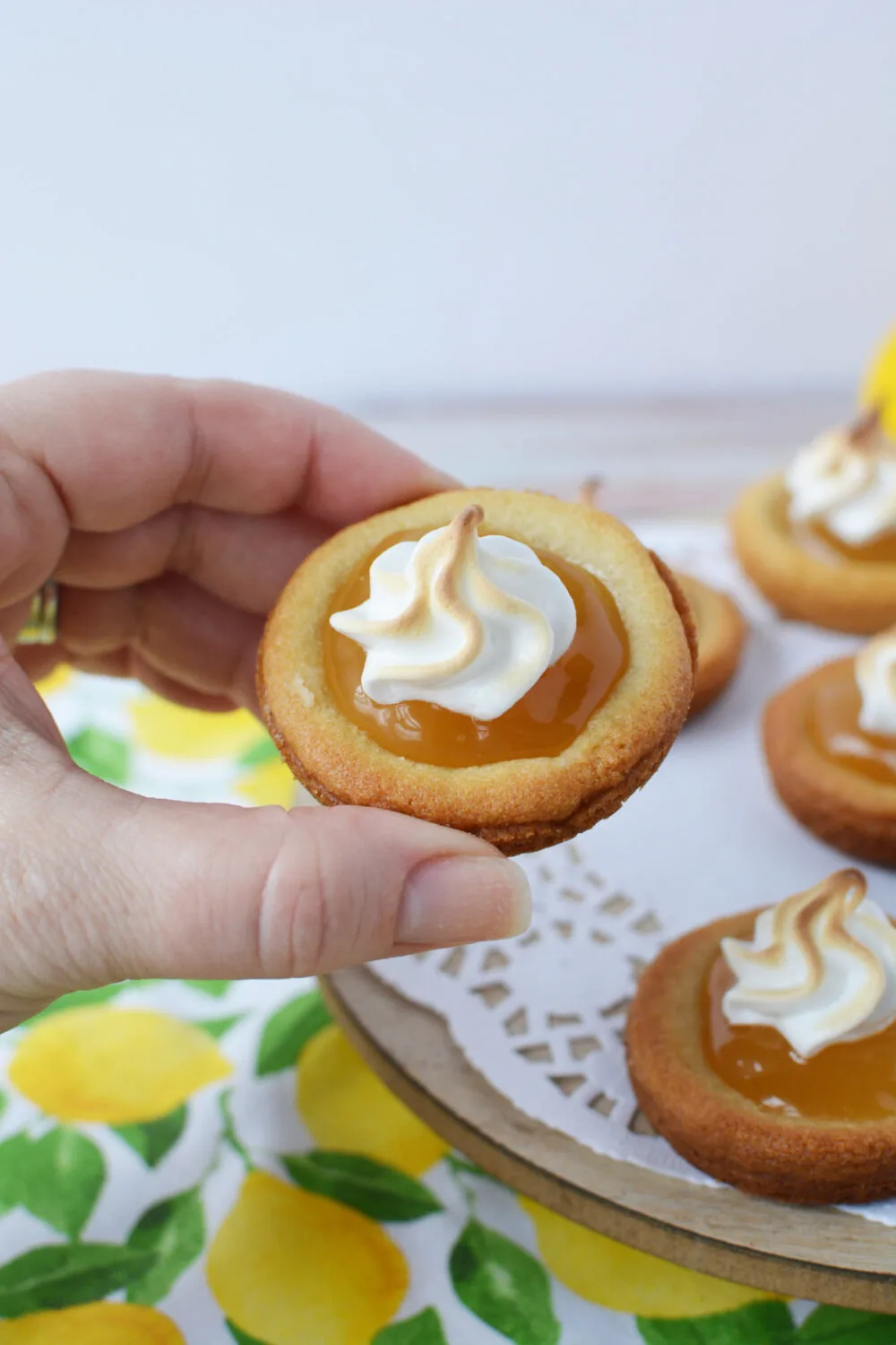 Holding a lemon curd cookie topped with meringue.