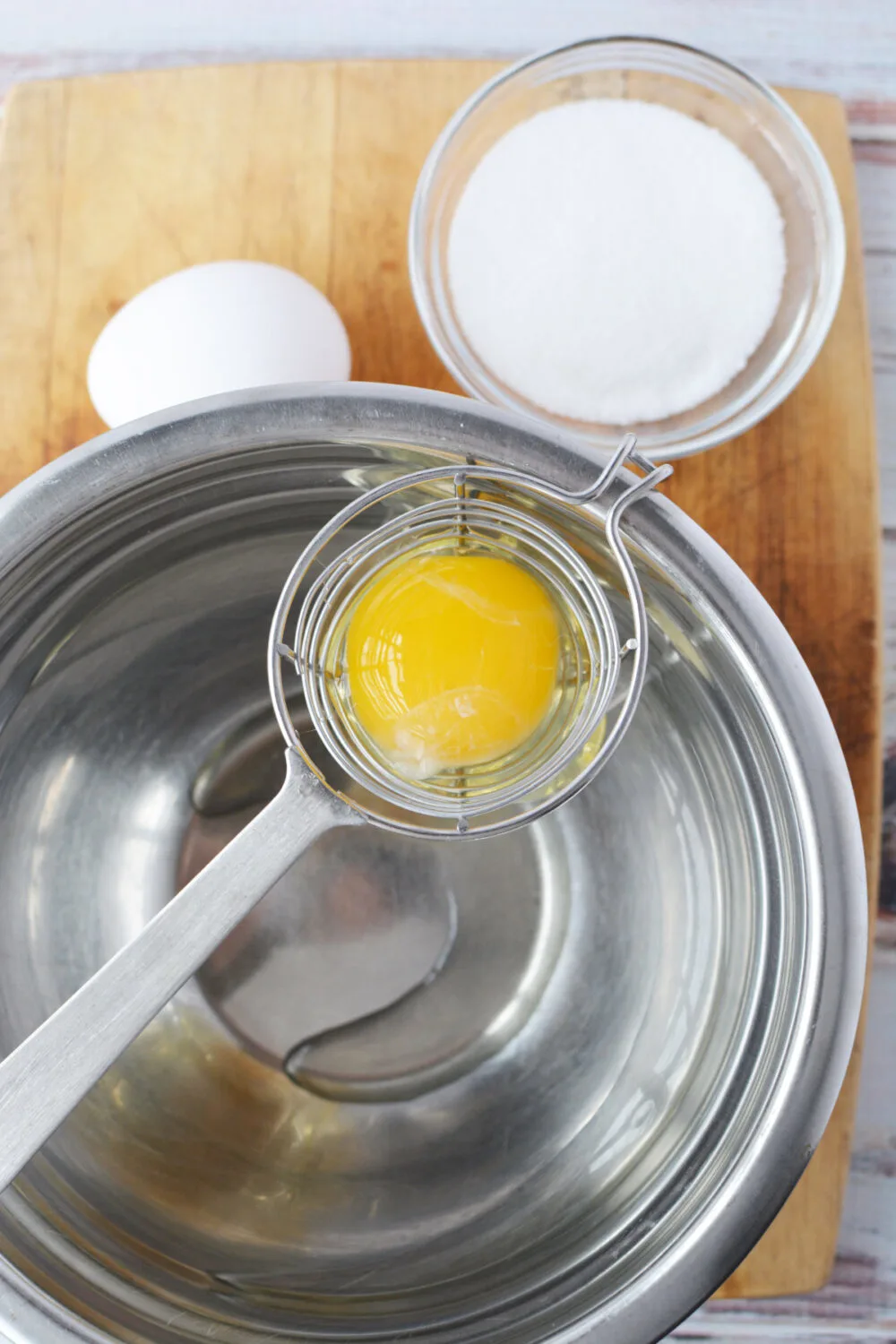 Adding egg whites to a mixing bowl. 