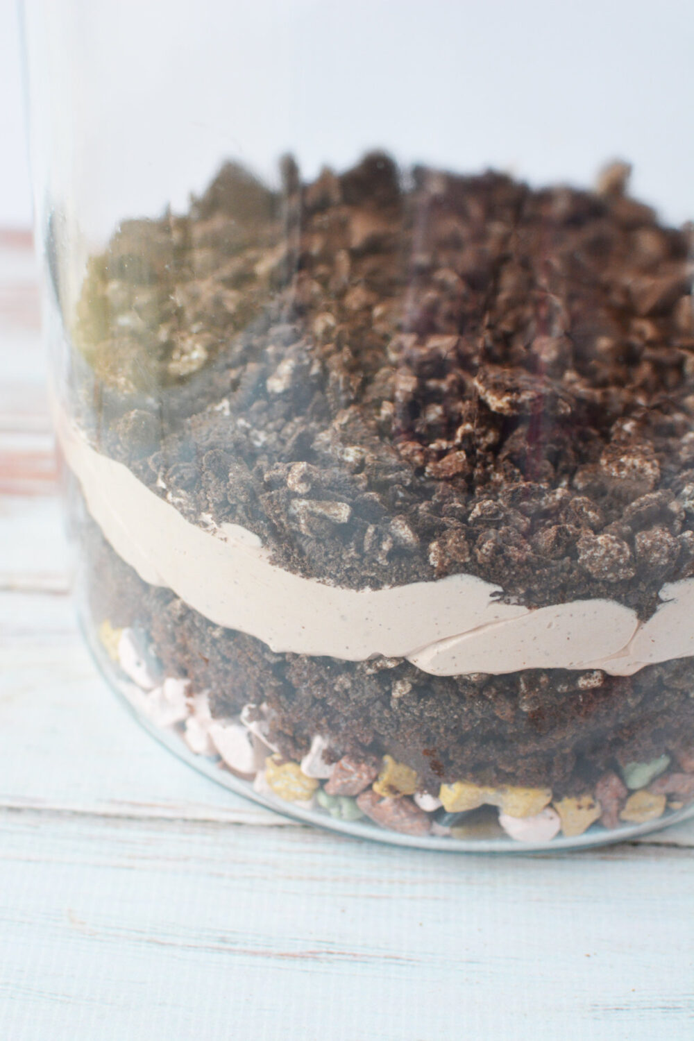 Crushed Oreo cookies on top of other layers in a jar