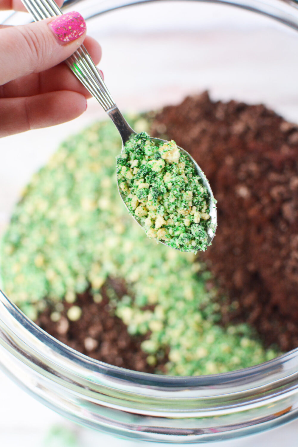 Spooning green crushed cookies into jar