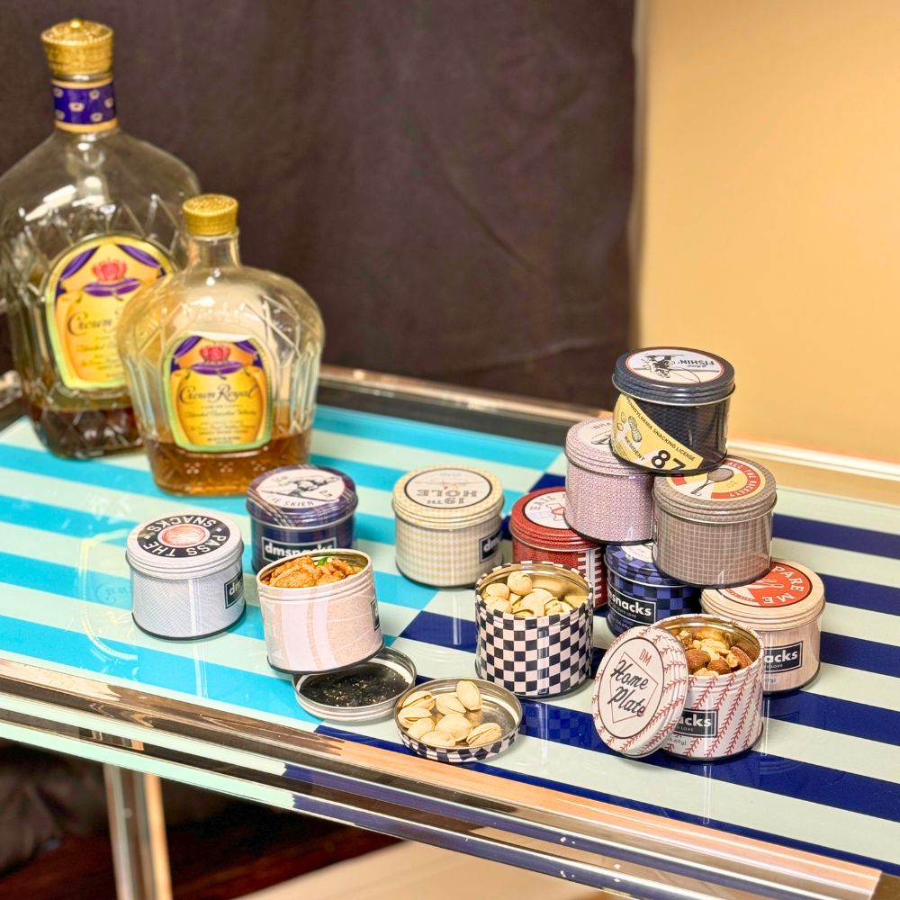 Tins of snack mix and nuts on a bar cart. 