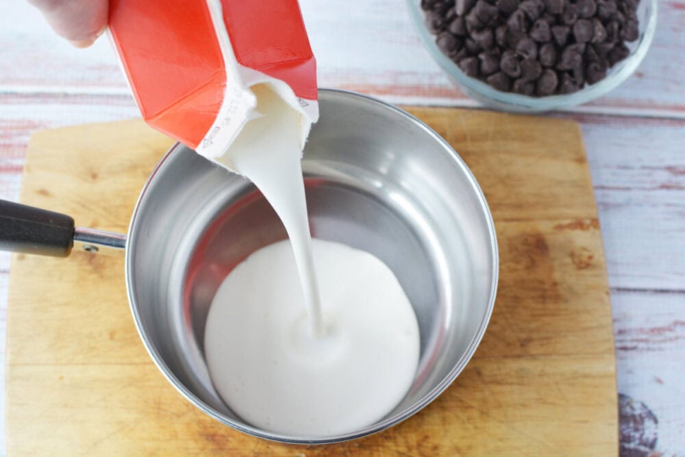 Pouring cream into a mixing bowl. 