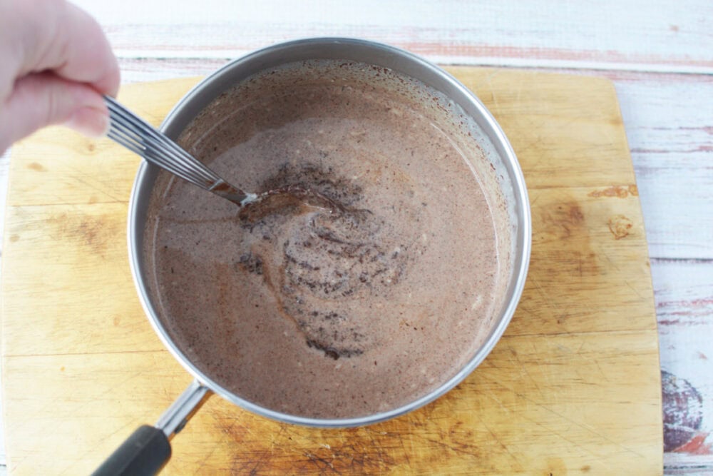 Mixing chocolate ganache in a saucepan.