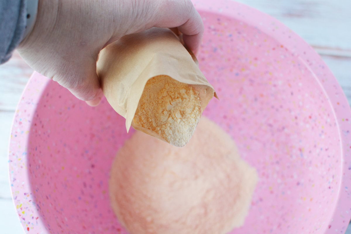 Adding pudding into mixing bowl.