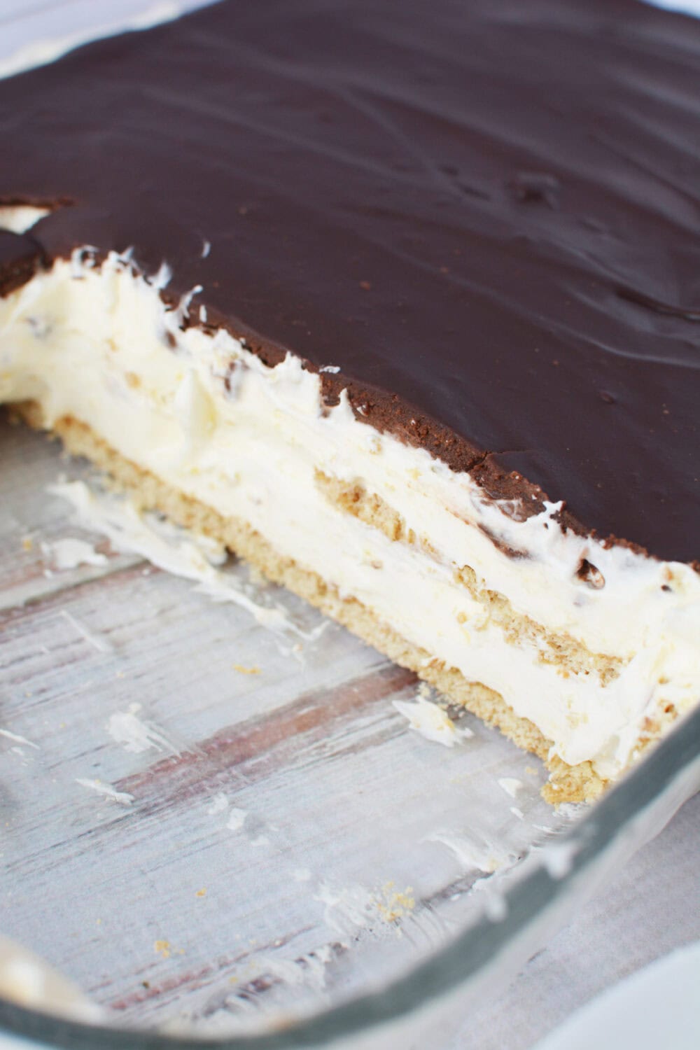 Slices missing from a pan of chocolate eclair cake. 