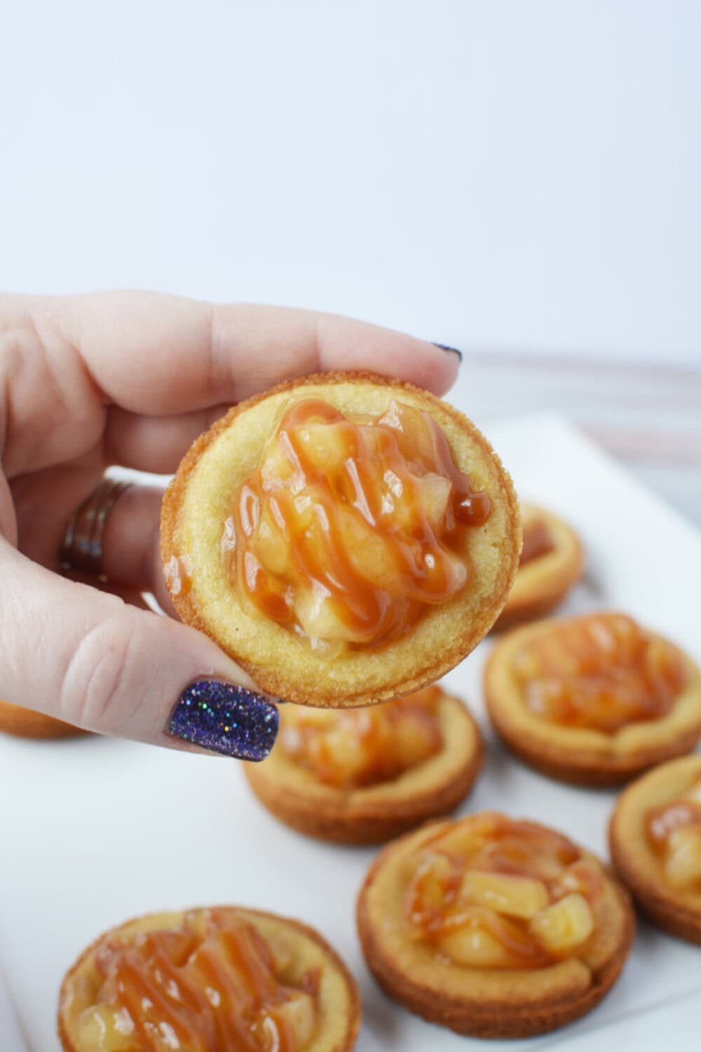 Holding a caramel apple pie cookie. 