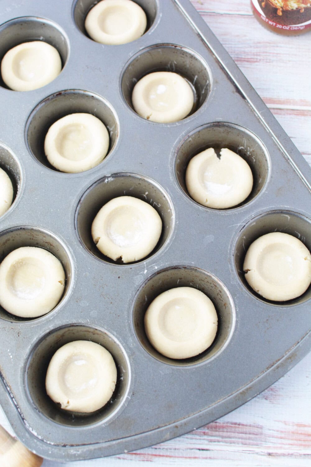 Sugar cookie crusts in a muffin tin before baking. 