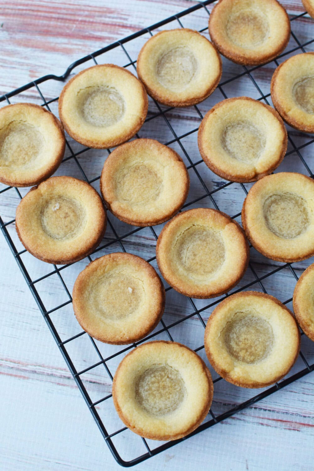 Baked sugar cookie dough crusts on a wire rack. 