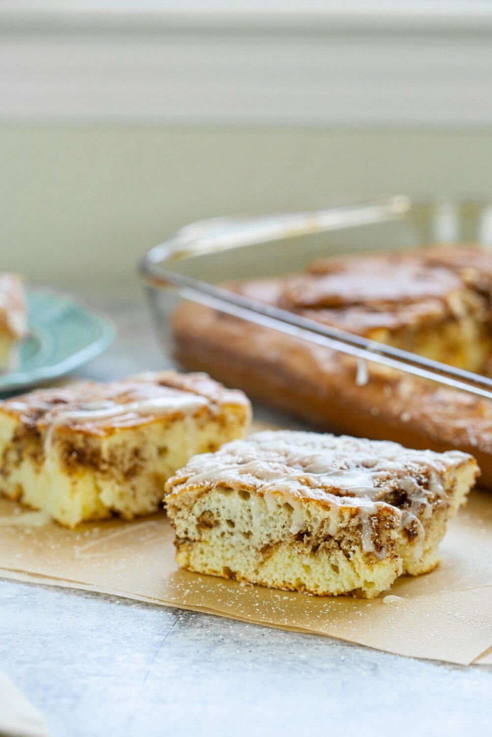 Slice of cinnamon roll cake in front of baking pan. 