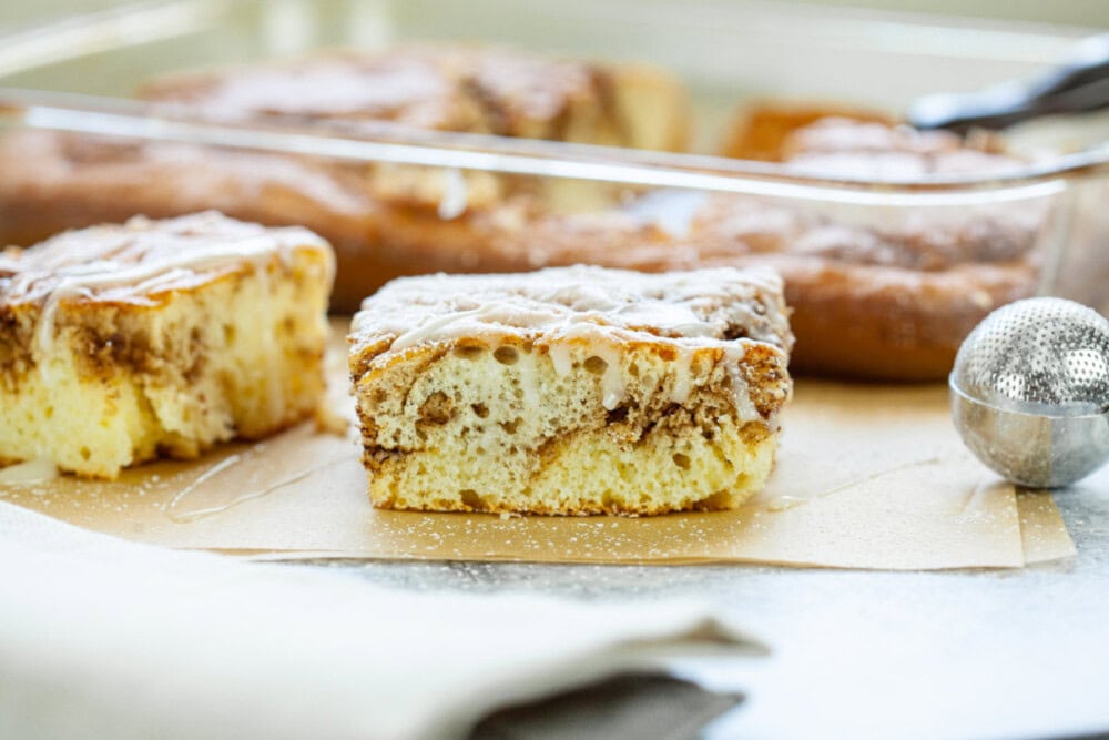 Slice of cake with cinnamon swirls and topped with glaze. 