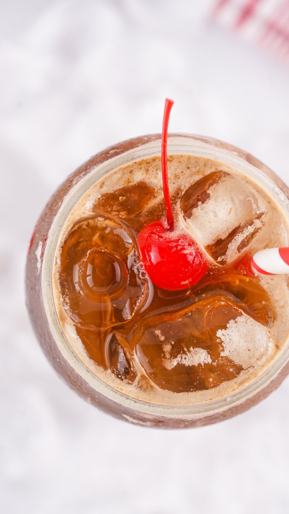 Overhead shot of a glass of Fluffy Coke with a cherry on top. 