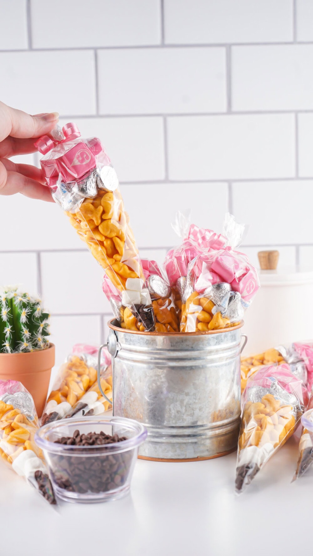 Pulling a pencil snack bag out of a silver bucket. 