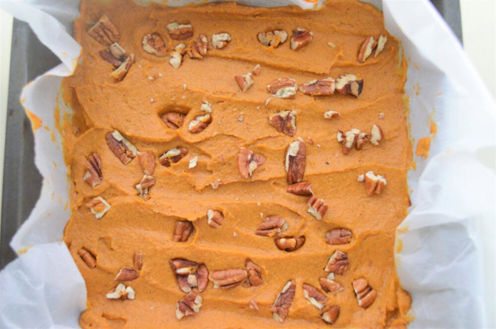 Pumpkin peanut butter fudge in the pan topped with chopped pecans. 