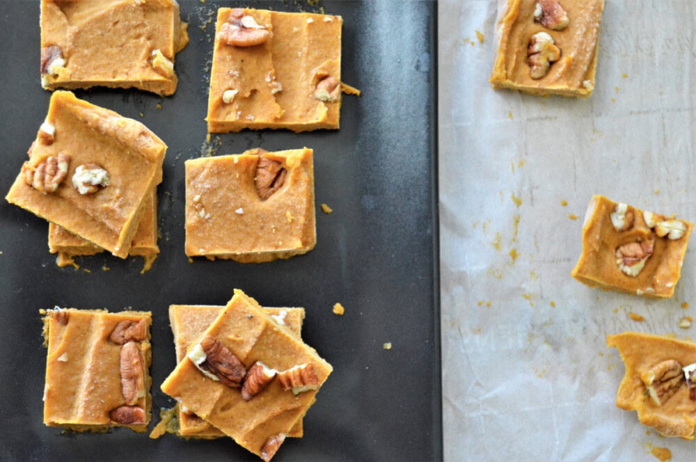 Slices of peanut butter pumpkin fudge on a board. 