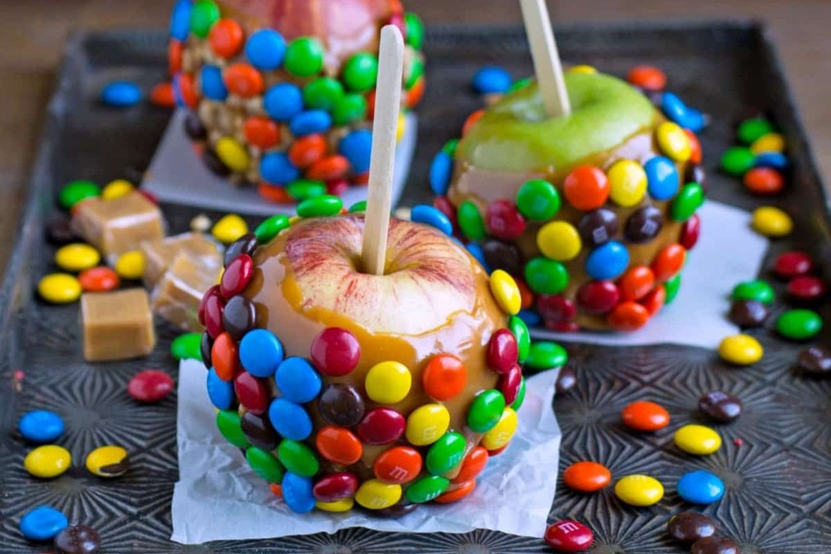 Caramel apples covered in M&M candies. 