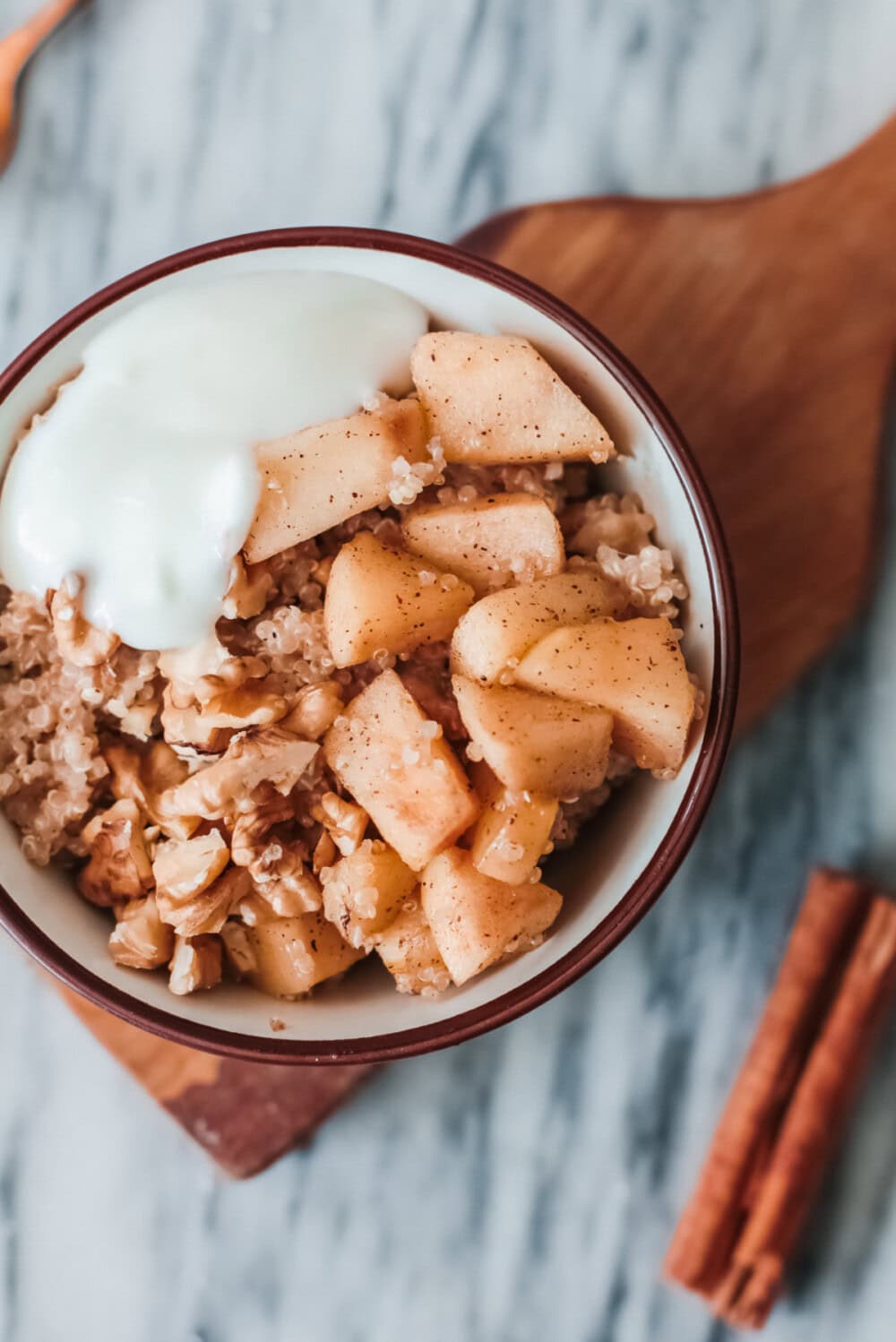 Quinoa apple breakfast bowl topped with yogurt. 