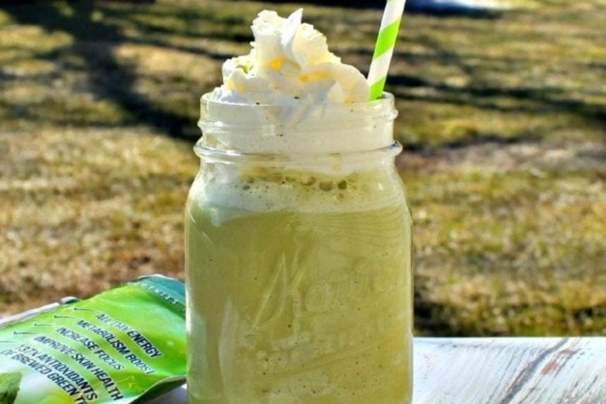 Green tea frappuccino topped with whipped cream. 