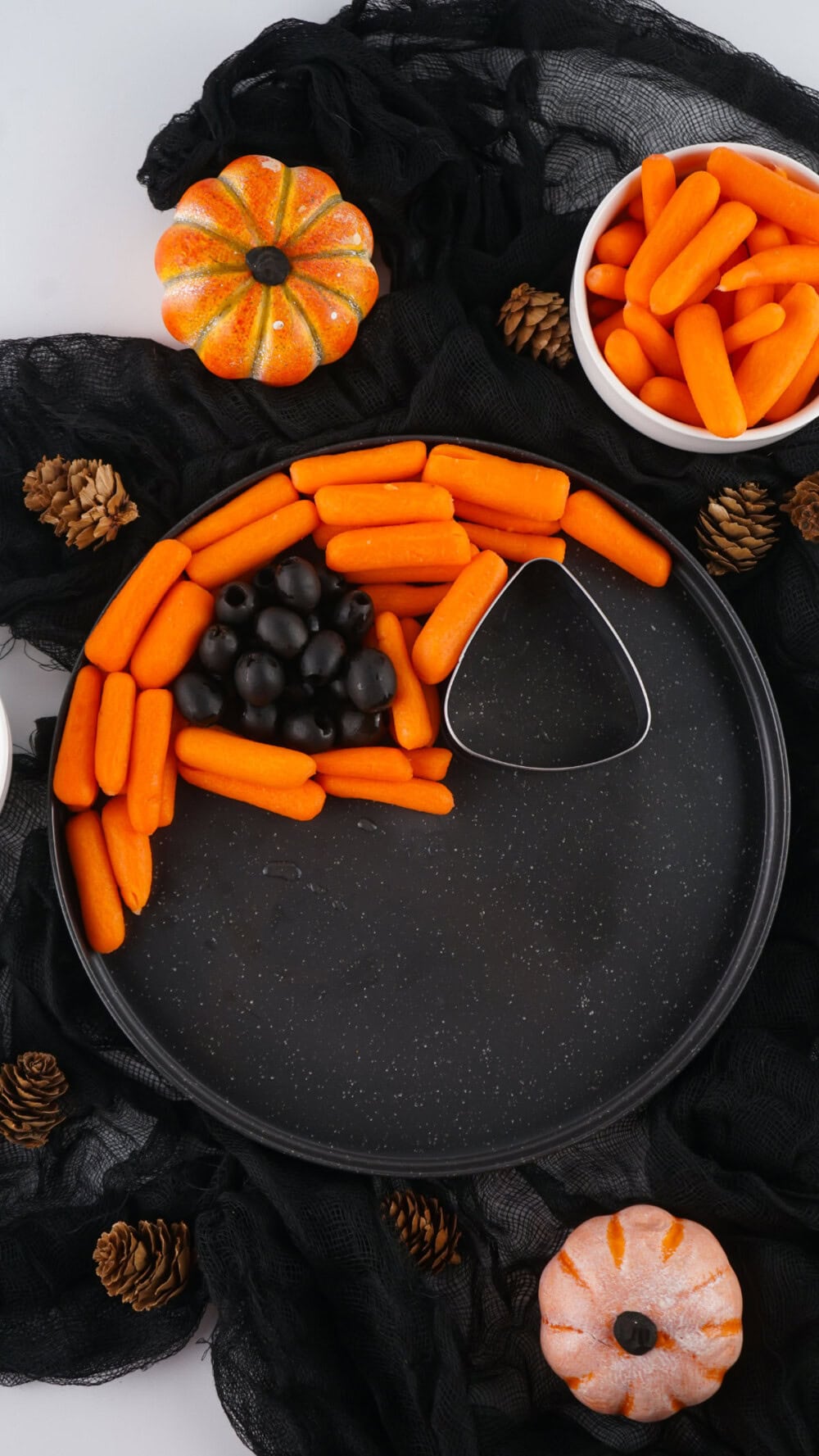 Baby carrots around olives in cookie cutters. 