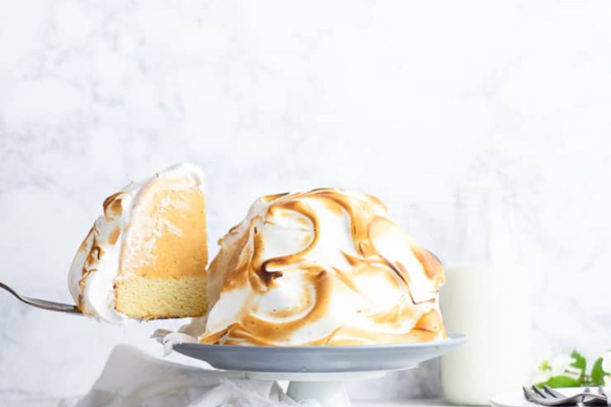 Pumpkin baked Alaska with a slice being removed. 