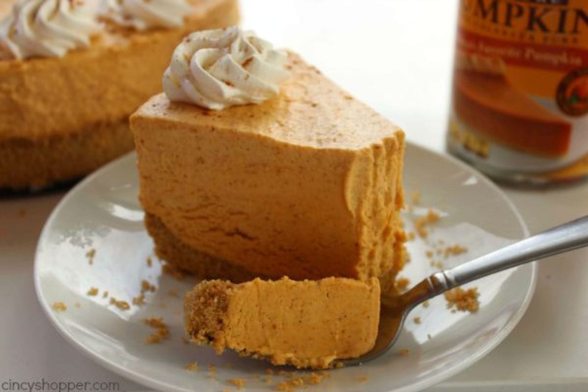 Slice of pumpkin cheesecake on a plate with a fork.