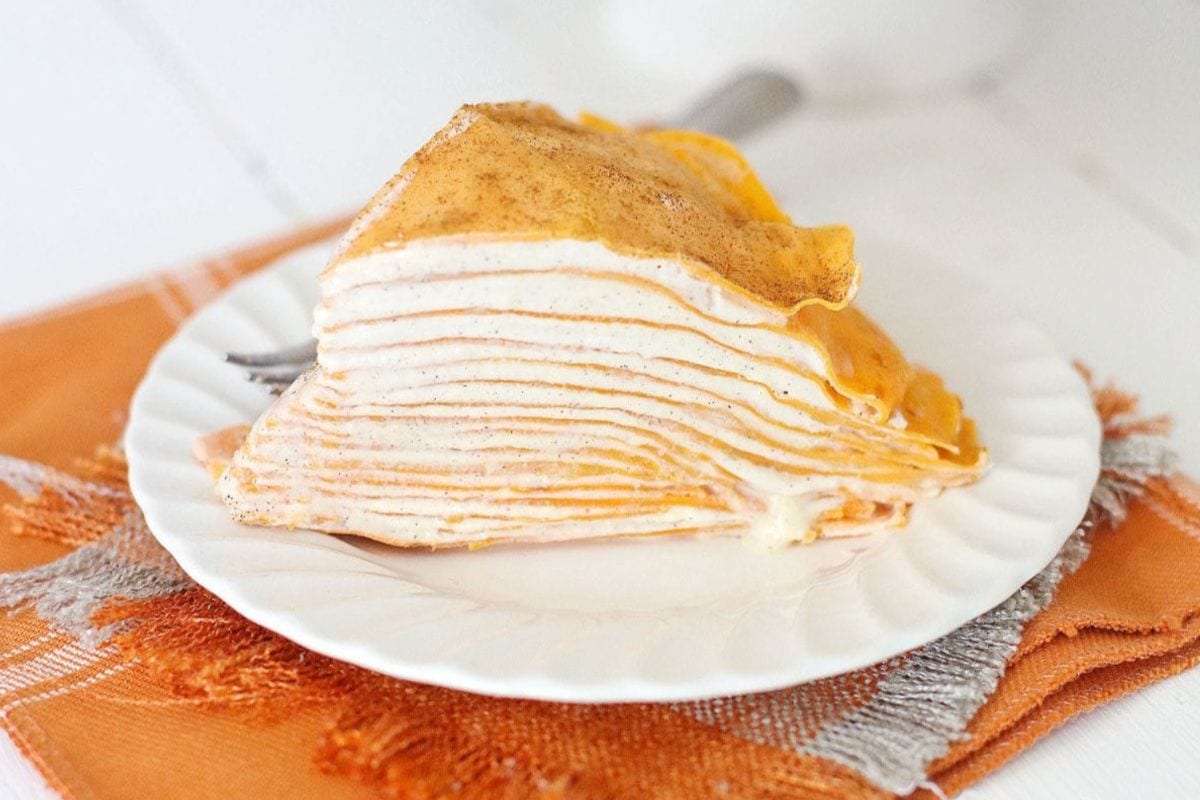 Slice of pumpkin crepe cake on a plate. 