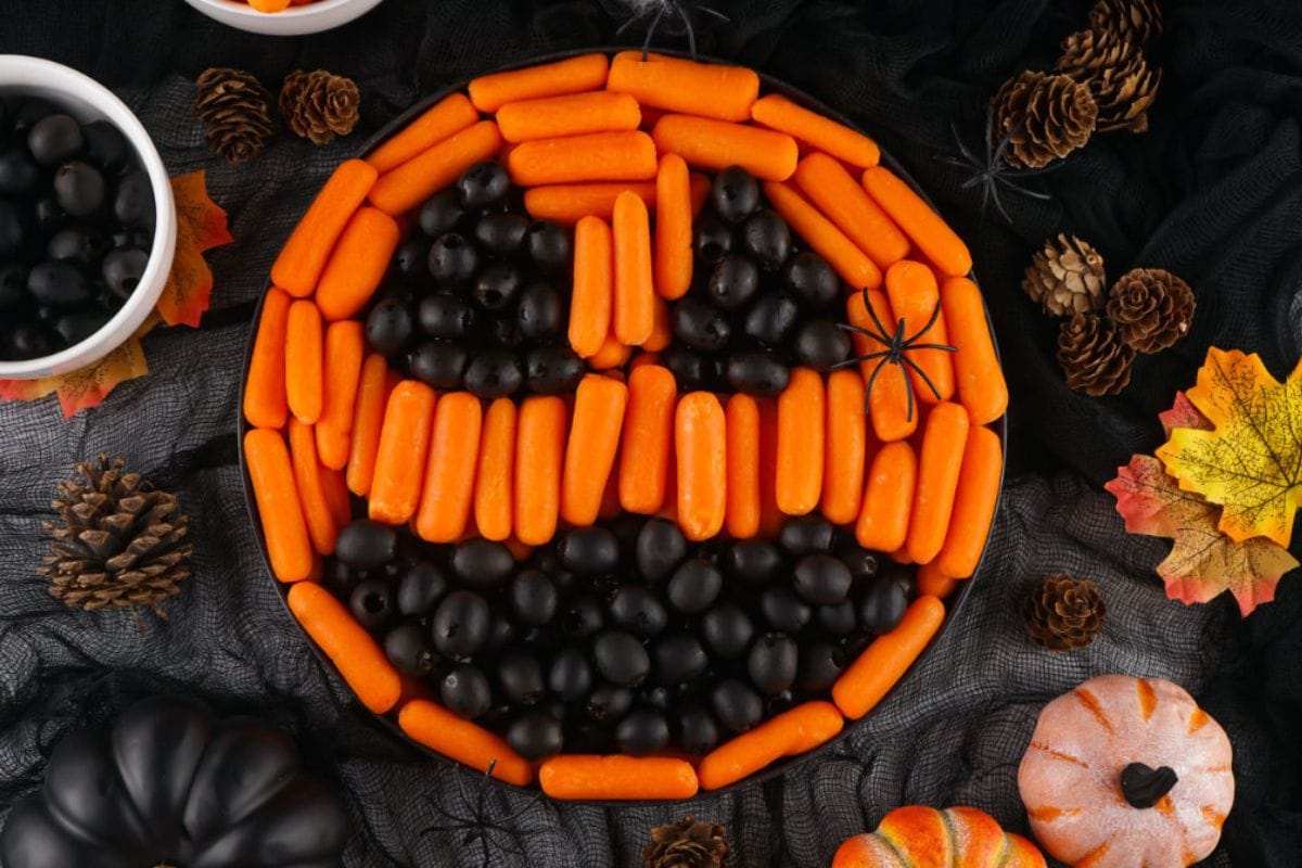 Carrots and olives arranged to look like a jack o'lantern. 