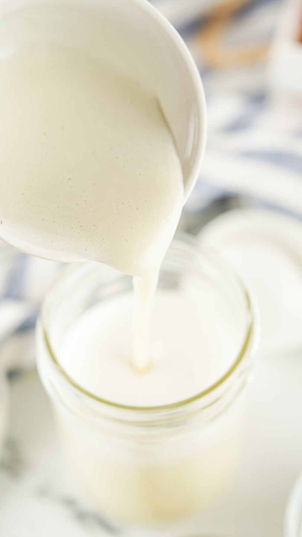 Pouring sweetened condensed milk into a jar. 