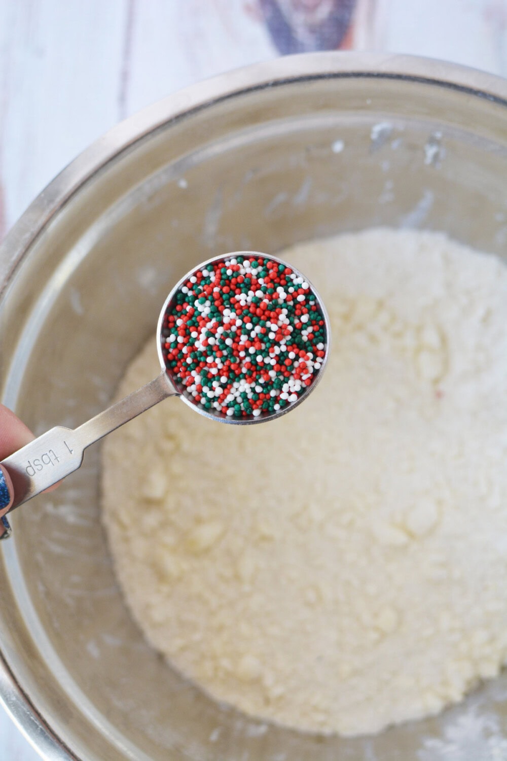 Adding nonpareils to cookie dough. 