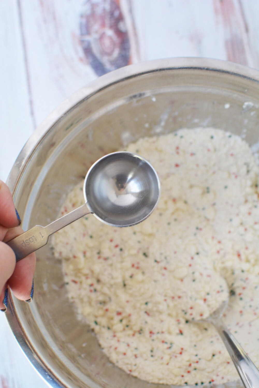 Adding water to cookie dough. 