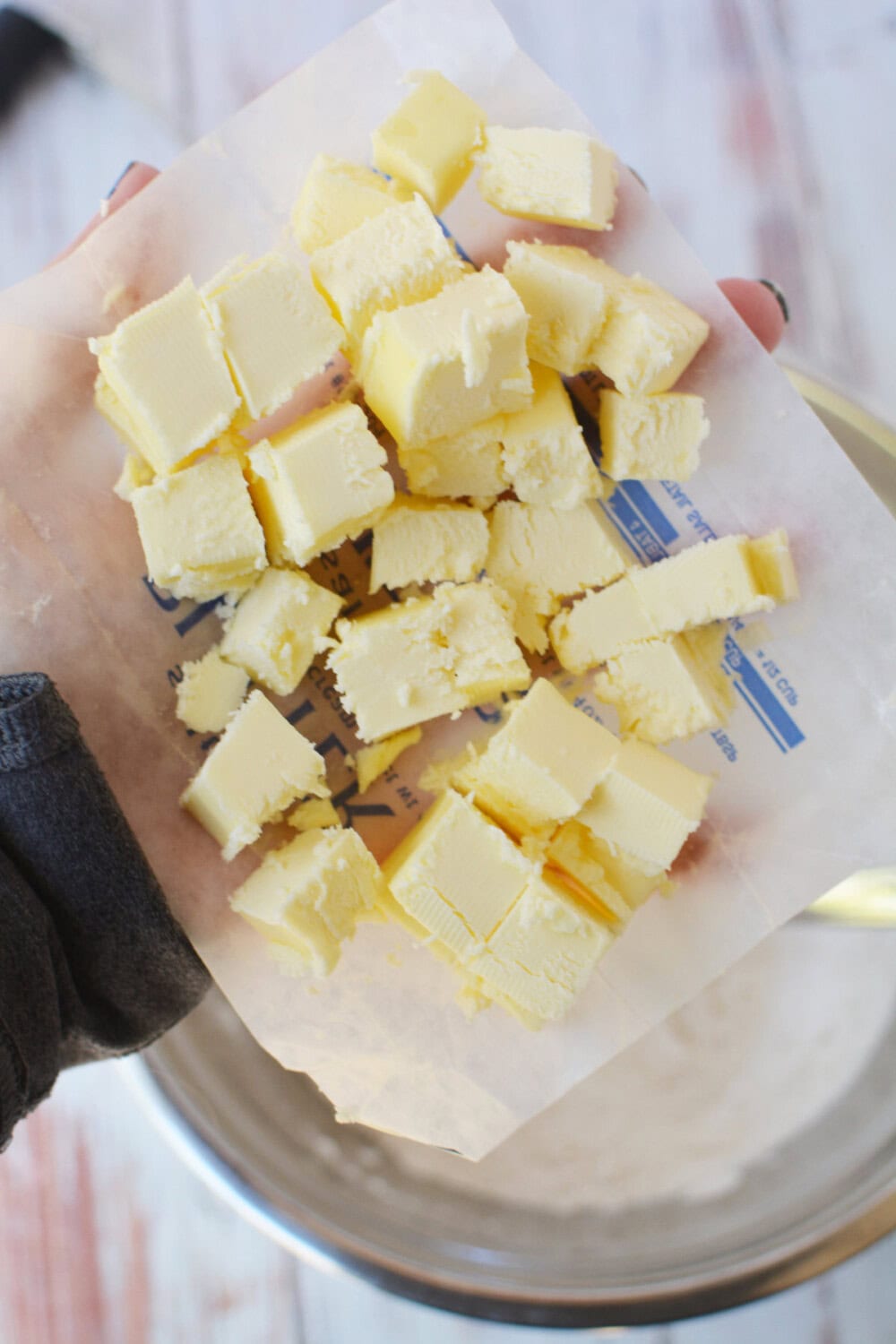 Adding cubes of butter to flour mixture. 