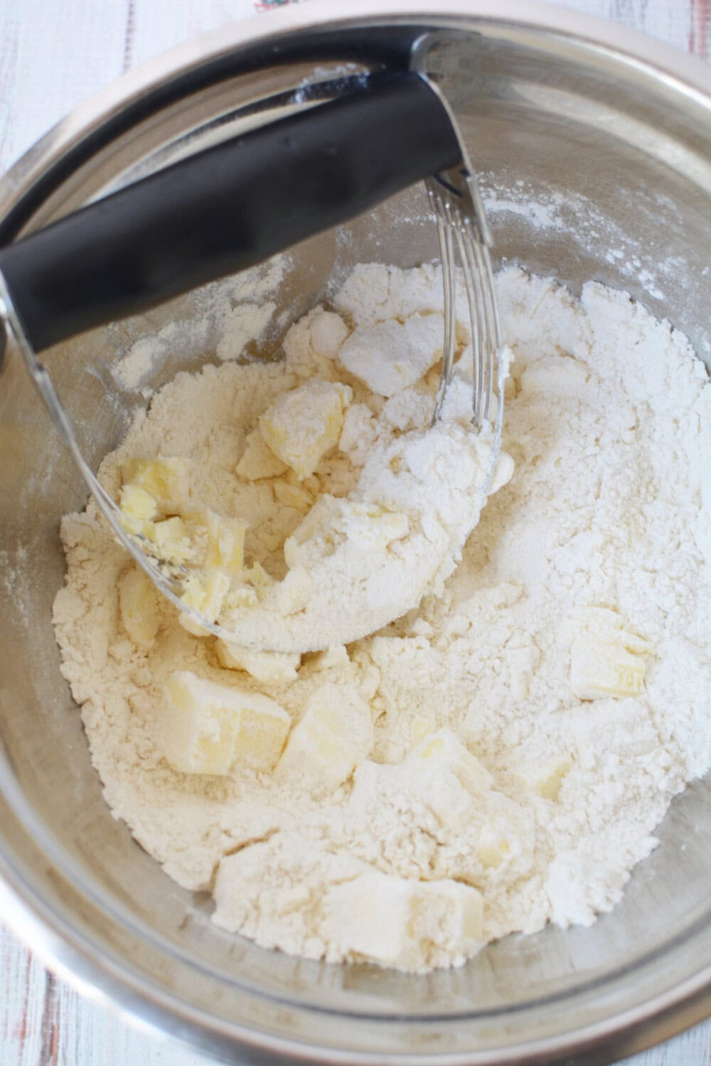 Using a pastry blender to cut butter into flour mixture. 