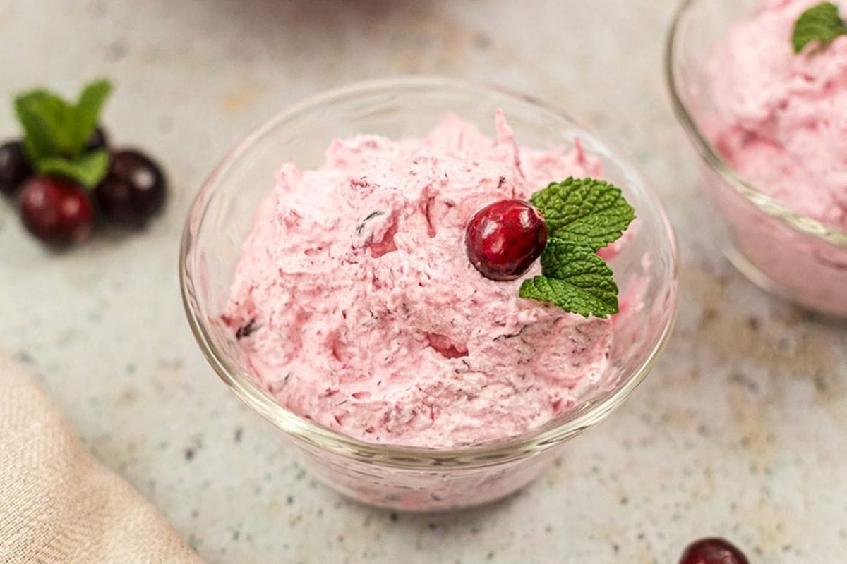 Cranberry fluff salad in a clear dish. 