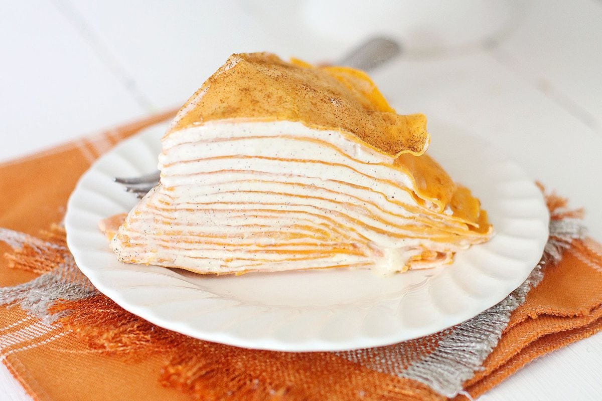 Slice of pumpkin crepe cake on a plate. 