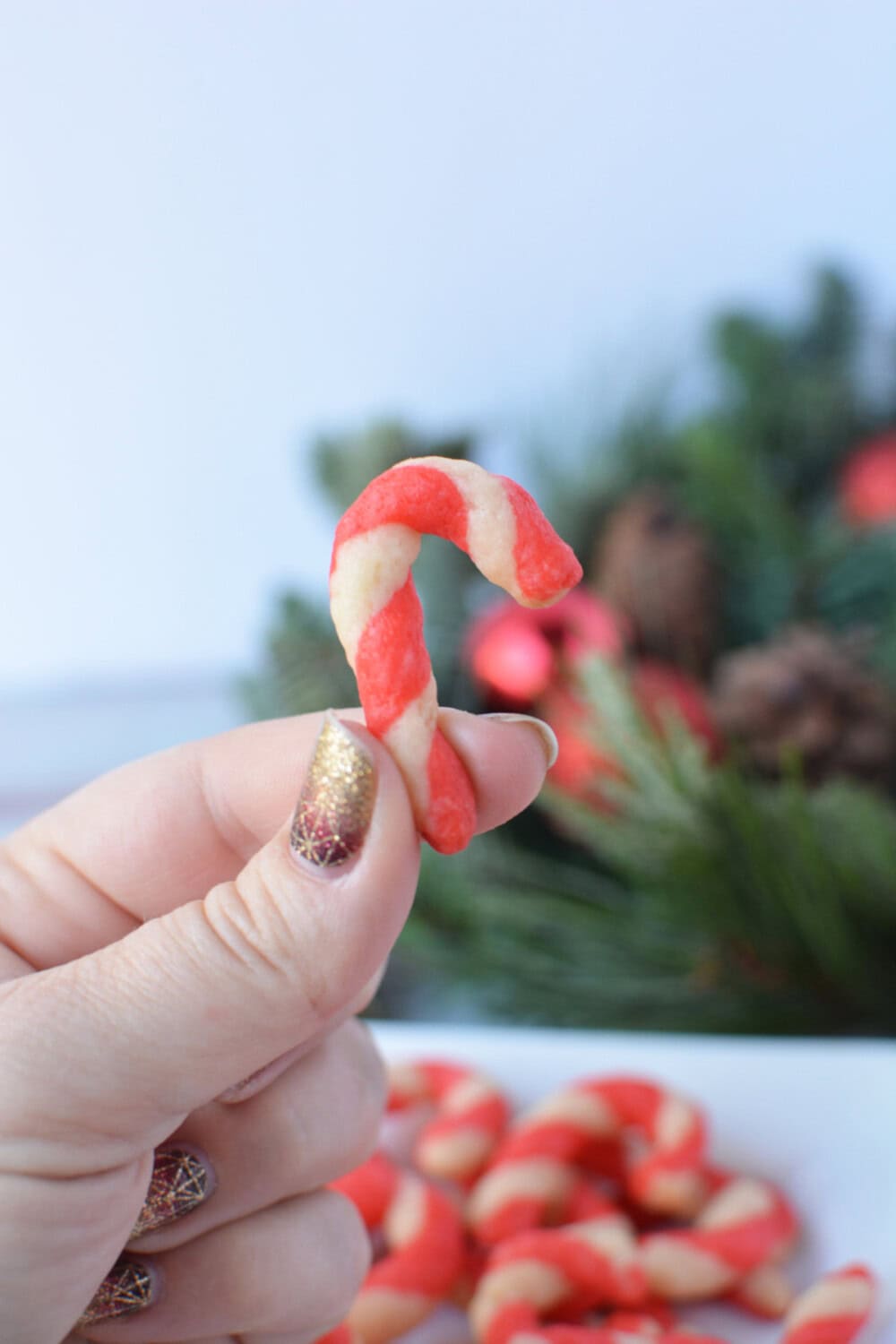 a hand holding a candy cane shortbread bite