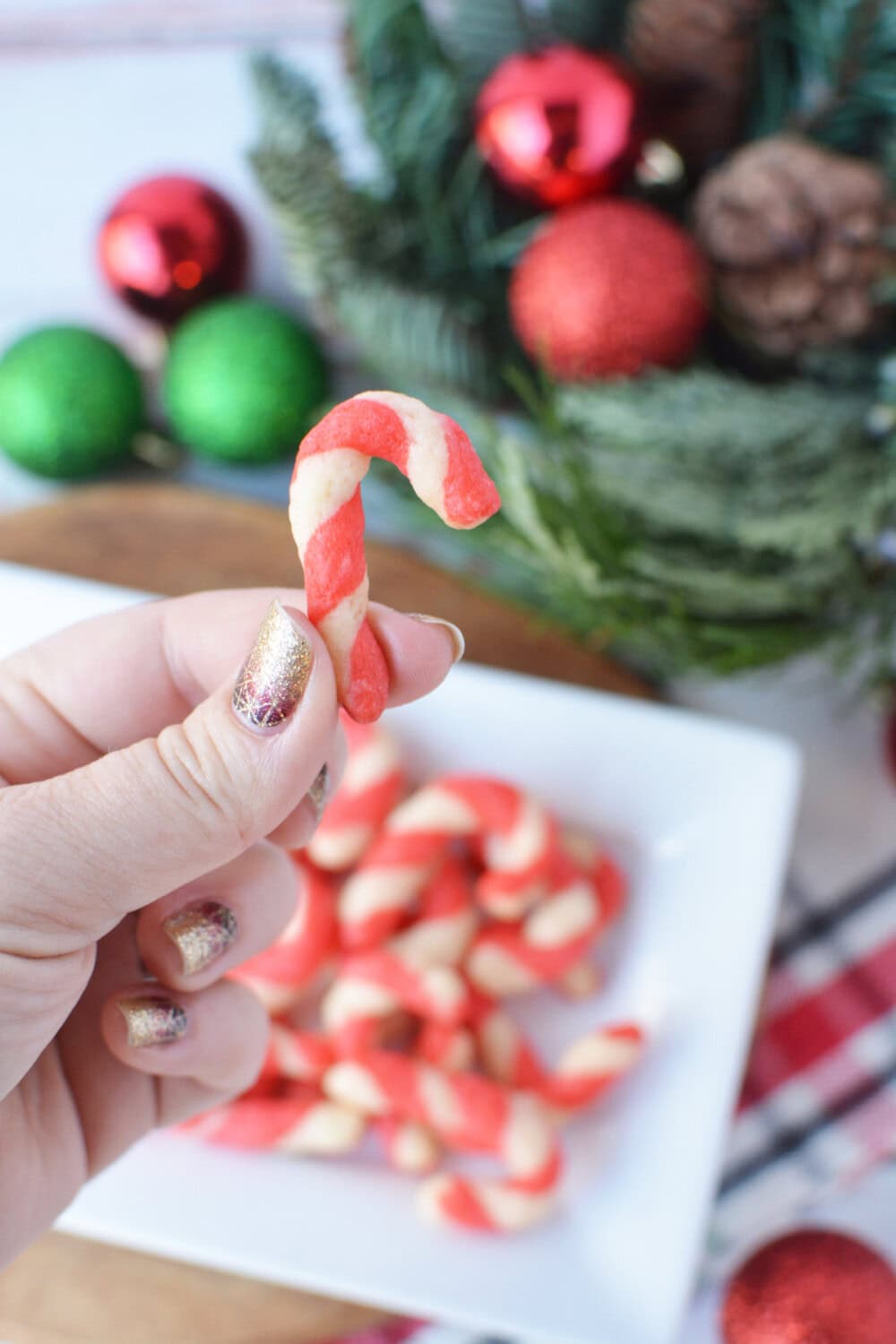 a hand holding a candy cane cookie