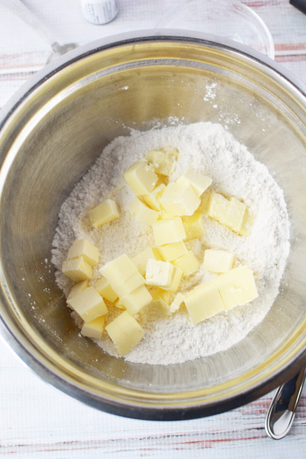 chunks of butter in a mixing bowl with flour and sugar