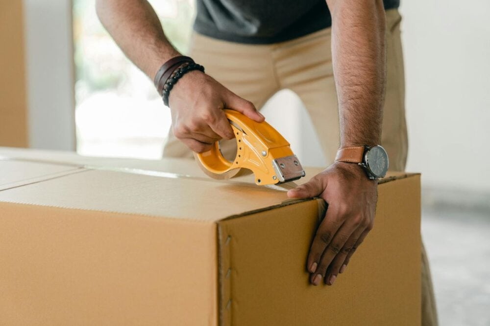 man taping a box with packing tape