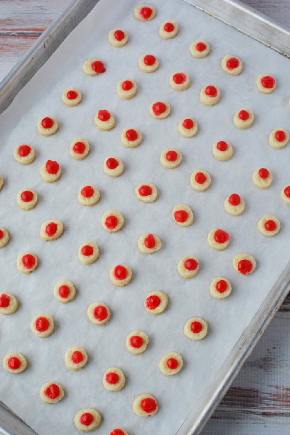 Cookies with red candies on a baking sheet