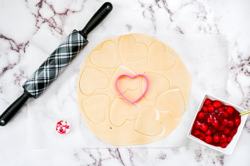 Heart-shaped cookie cutter on pie crust.