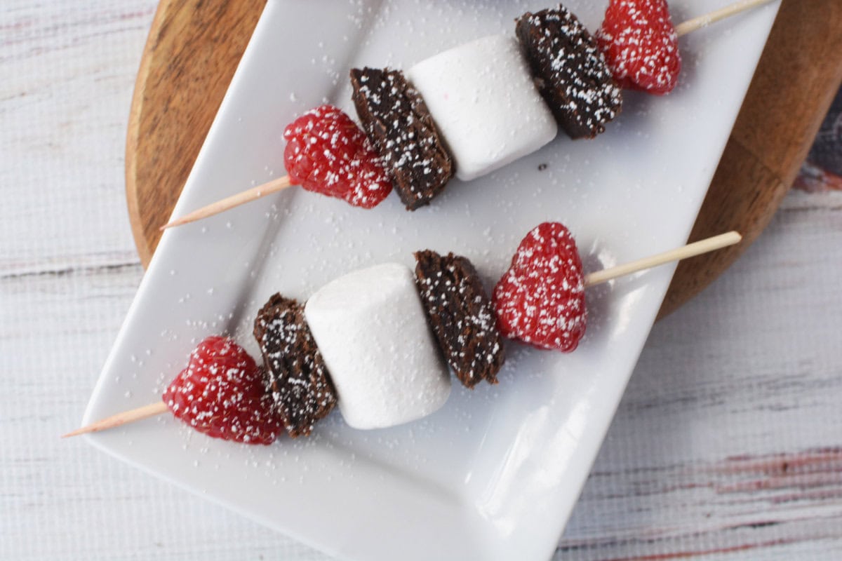 Brownies, marshmallows, and raspberries on a skewer.