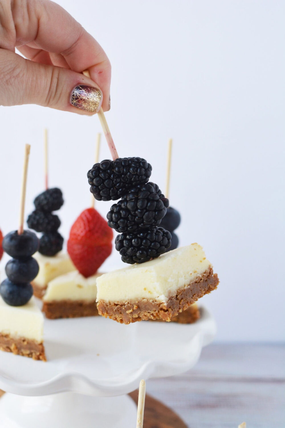 Blackberries on a skewer with cheesecake.